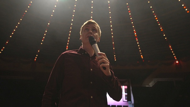Till Reiners mit Mikrofon in der Hand, während er grade seine Comdey Bühnenshow performt. | Bild: BR